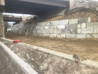 The retaining wall will provide access for pedestrians and bicyclists temporarily throughout phase 2 construction and permanently through the installation of the future shared-use path.