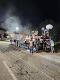 Crews mill the roadway surface in preparation for paving.