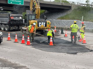 Crews paving disturbed segments of roadway with temporary pavement.