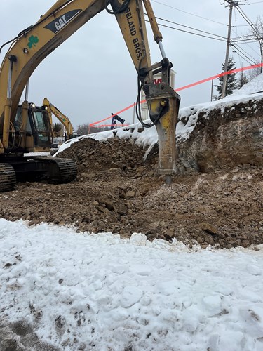 Crews hammer ledge along Mountain View Drive in Colchester, VT.