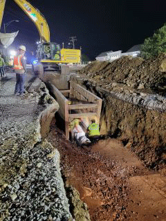 Crews working to install underground utility - waterline.