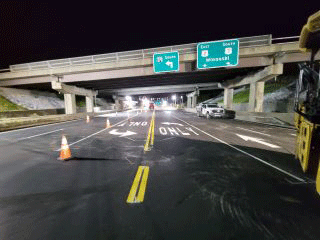 Crews installing pavement markings and line striping throughout the project area.