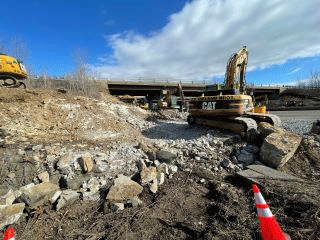 Crews mechanically break up and remove ledge to facilitate the installation of the retaining wall along the west side of U.S. 2/7.