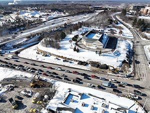 Aerial view of construction progress in December 2025. Drainage infrastructure installation along U.S. 2/7 between I-89 ramps and Mountain View Drive. Retaining wall construction in The Lighthouse Restaurant parking lot along U.S. 2/7. Traffic signal work at the intersection of U.S. 2/7 and Mountain View Drive.