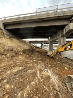 Crews removing earth material to facilitate the installation of the retaining wall along the west side of U.S. 2/7.